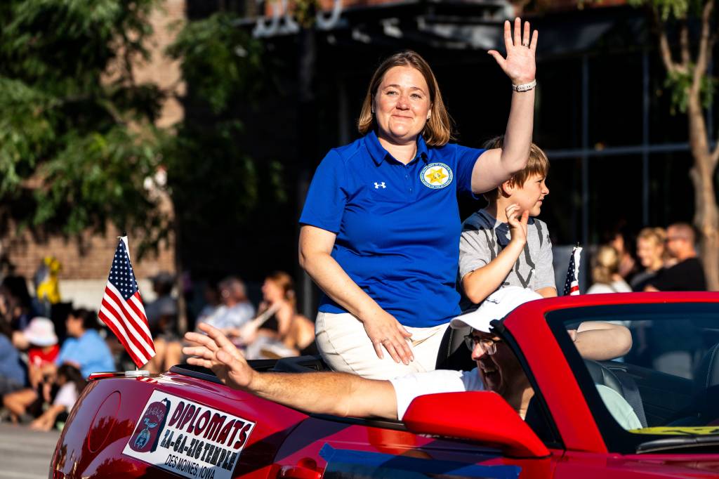 Iowa Attorney General Brenna Bird waves in a vehicle.