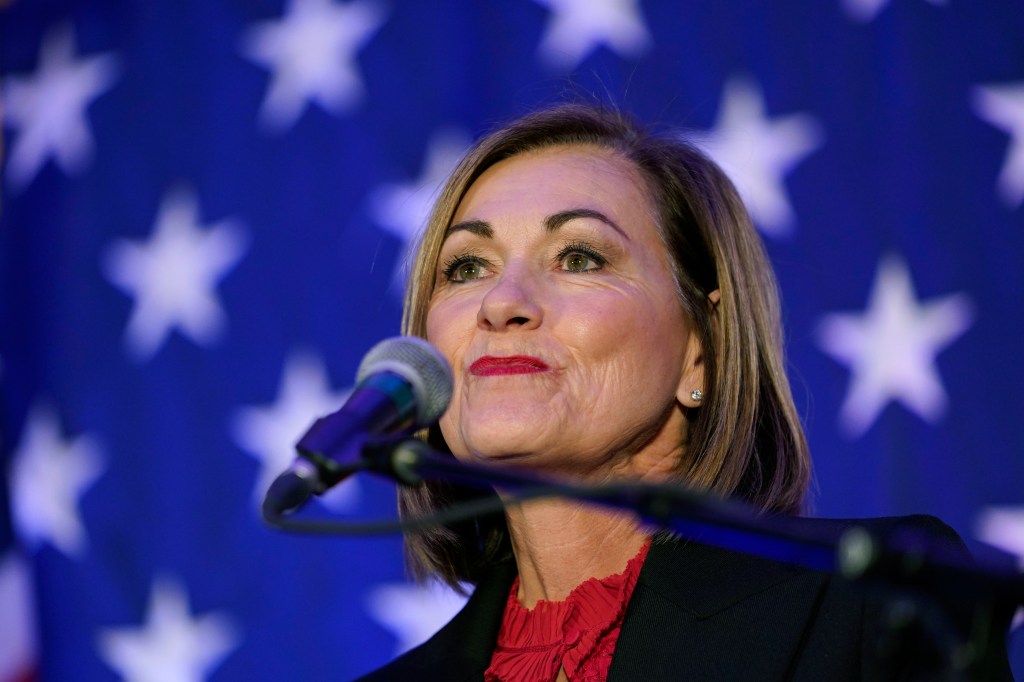 Iowa Governor Kim Reynolds speaking into a microphone at a Republican Party election night rally in Des Moines, Iowa, on November 8, 2022.