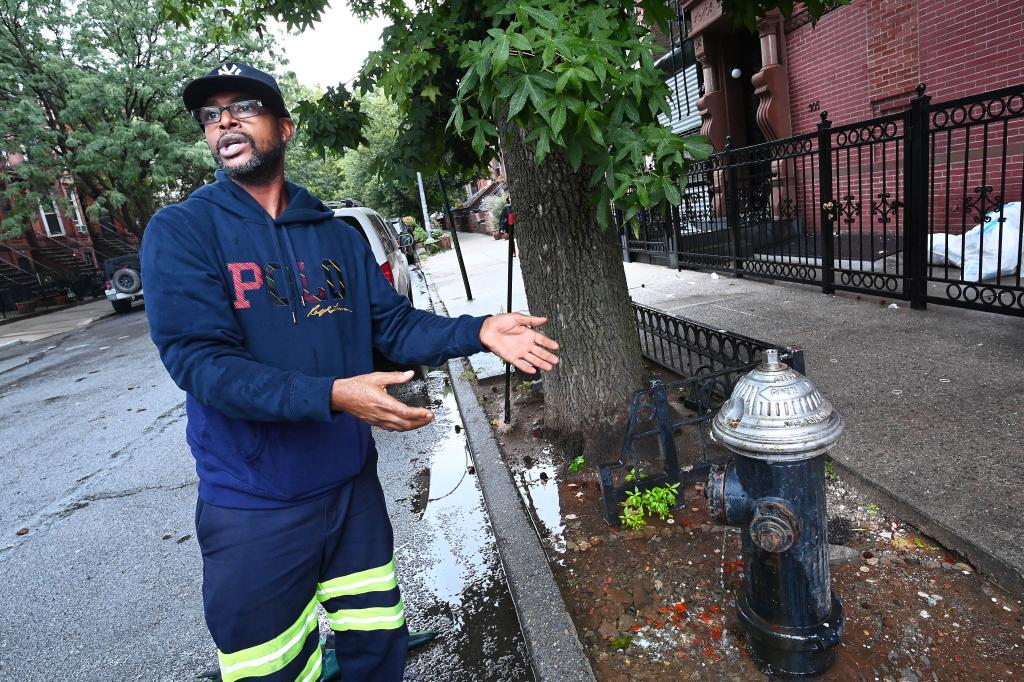 Je-Quan Irving, 47, at the community goldfish pond he and other men in Bed-Stuy set up around a leaking, decommissioned fire hydrant on Hancock Street.