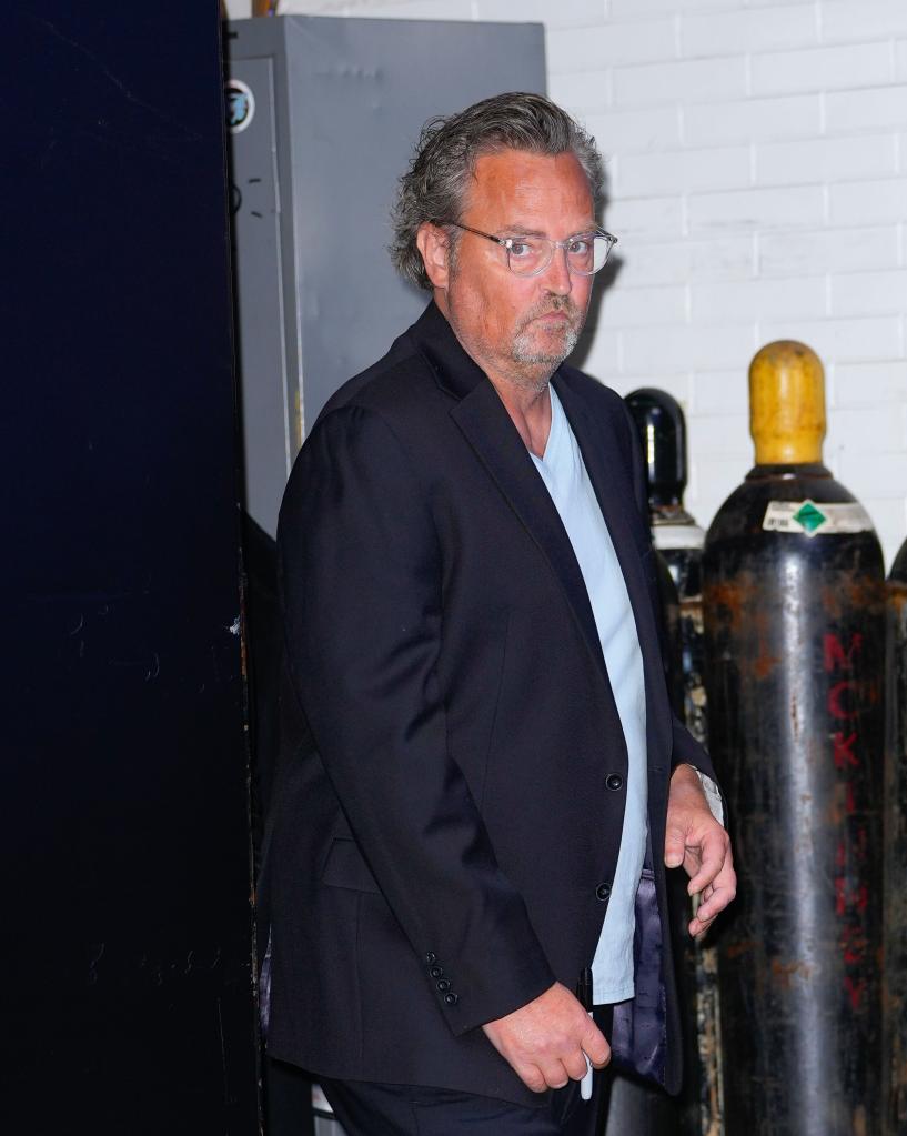 Matthew Perry in a suit, leaving GMA on October 31, 2022 in New York City