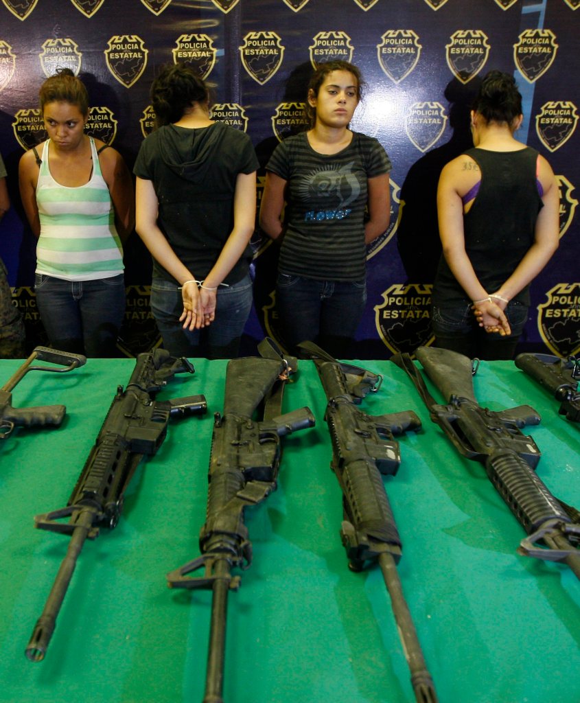 Suspected members of Los Zetas cartel and a table of guns.