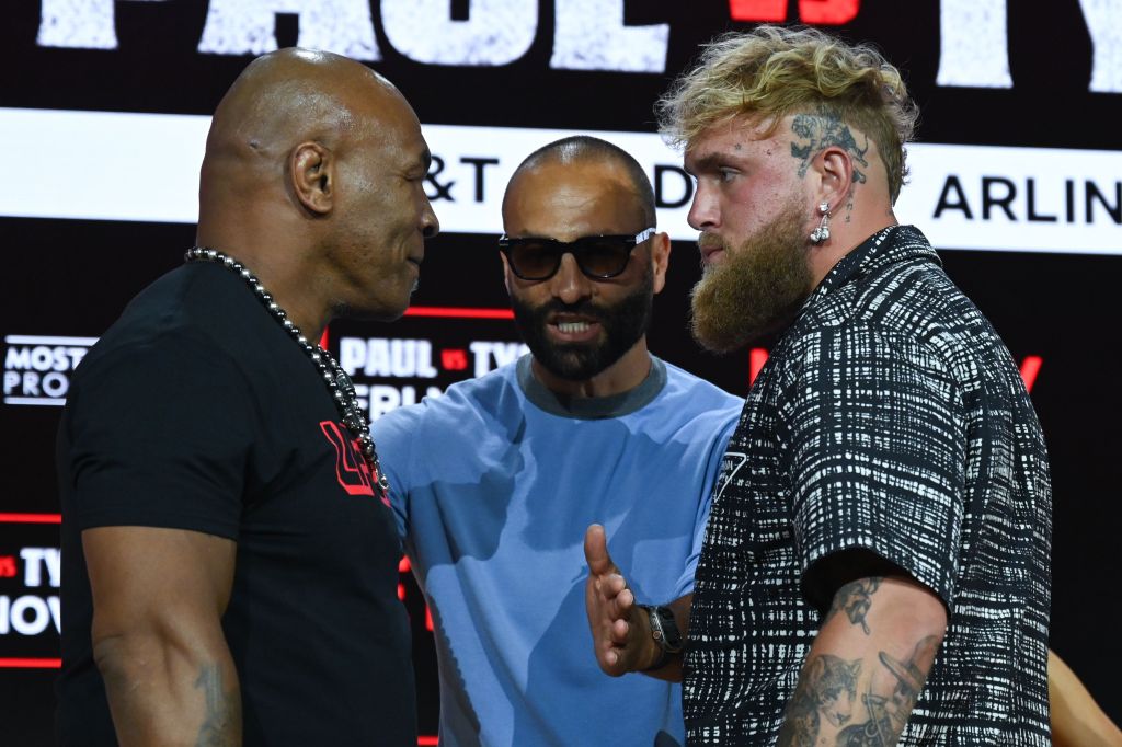 Mike Tyson, Ryan Clark and Jake Paul pose onstage during the Jake Paul vs. Mike Tyson Boxing match press conference at Fanatics Fest NYC at the Javits Center on August 18, 2024.