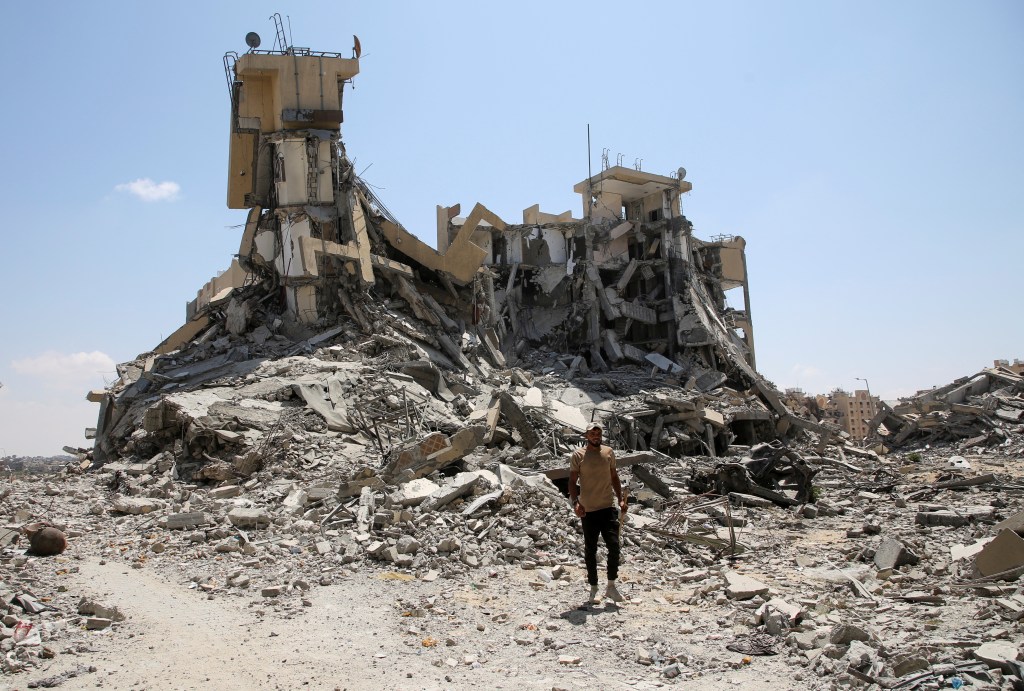 A Palestinian man stands amid rubble of destroyed buildings in Qatari-funded Hamad City, following an Israeli raid.