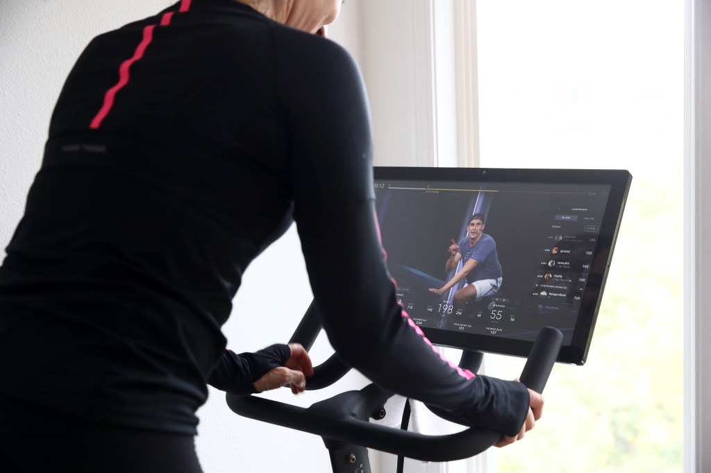 Woman, Cari Gundee, exercising at home on her Peloton stationary bike during COVID-19 shelter-in-place orders in San Anselmo, California.