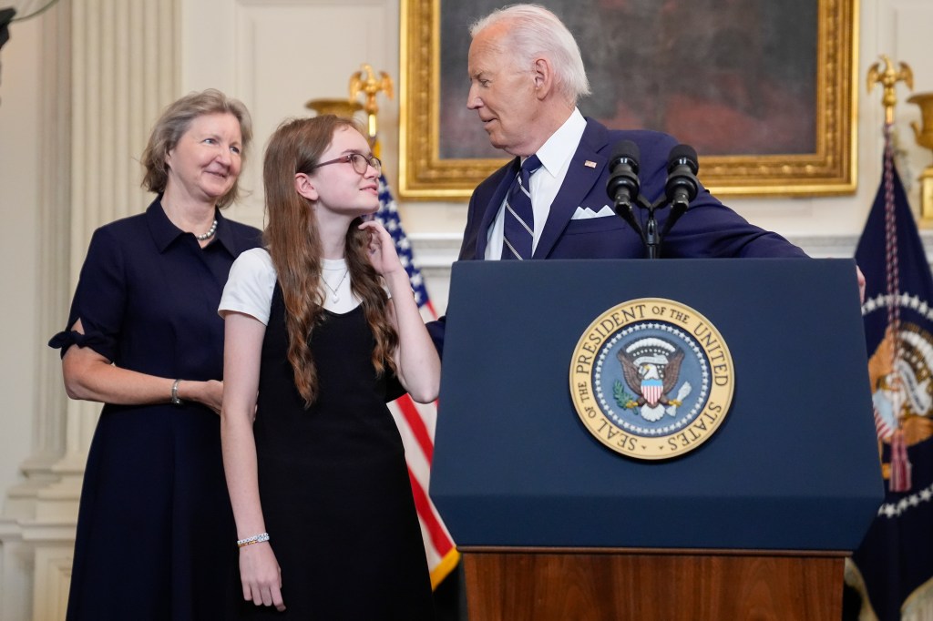 President Joe Biden, right, looking over to Miriam Butorin, center, as Elizabeth Whelan, left, looks on after he delivered remarks on a prisoner swap with Russia from the State Dining Room of the White House, Thursday, Aug. 1, 2024, in Washington. 