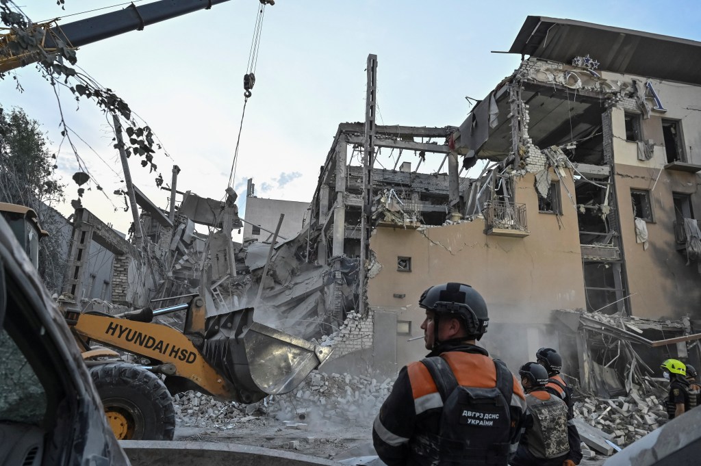 Rescue workers clearing debris in front of a destroyed building due to a Russian missile strike in Kryvyi Rih, Ukraine