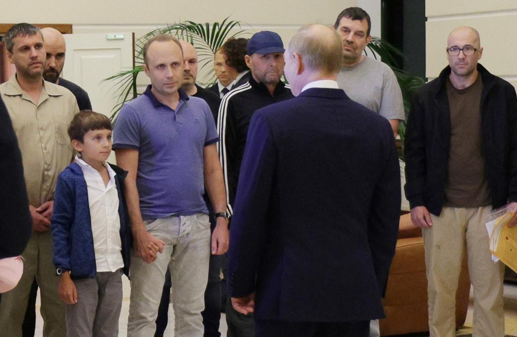 Russian President Vladimir Putin, front, greets released Russian prisoners and relatives at the government terminal of the Vnukovo airport in Moscow, Russia, Aug. 1, 2024.