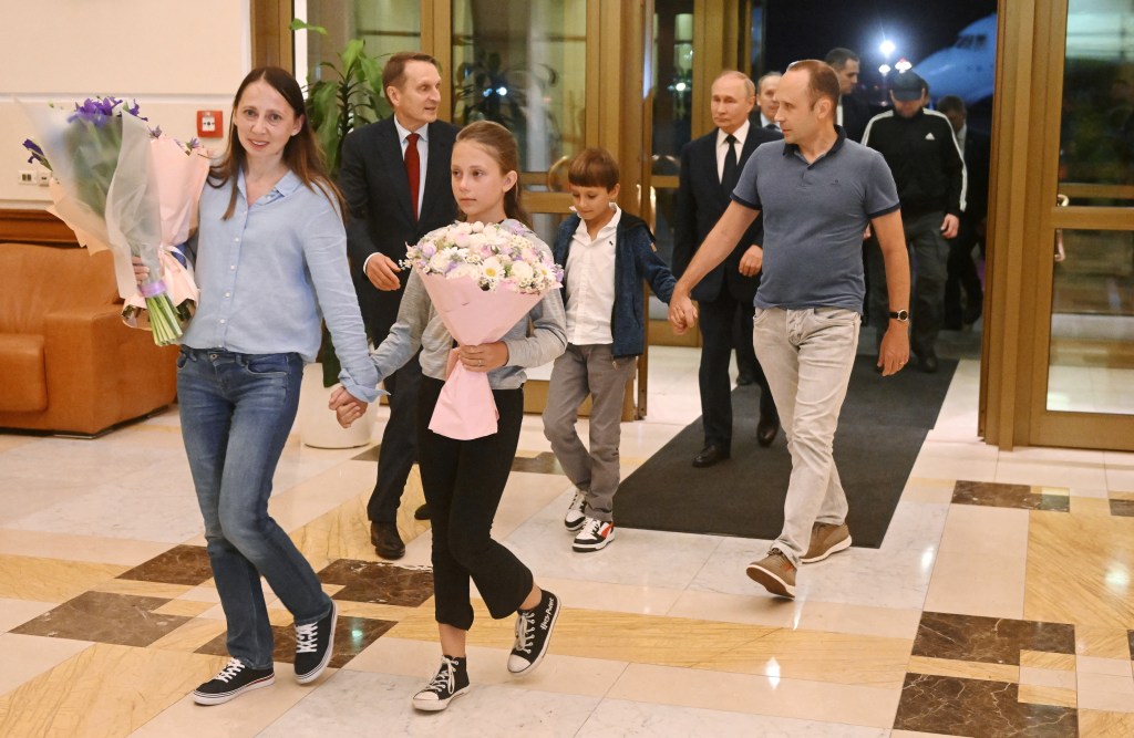 Vladimir Putin walks behind Russian nationals Artyom Dultsev, Anna Dultseva and their children following a prisoner exchange during a welcoming ceremony at Vnukovo International Airport in Moscow, Russia August 1, 2024.