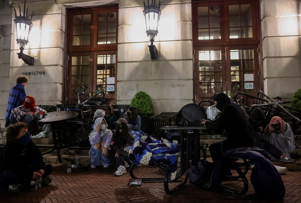 Student protesters sit watch outside Hamilton Hall, where students at Columbia University continue protesting in support of Palestinians barricaded themselves inside the building despite orders from university officials to disband a protest encampment, or face suspension, during the ongoing conflict between Israel and the Palestinian Islamist group Hamas, in New York City, U.S., April 30, 2024