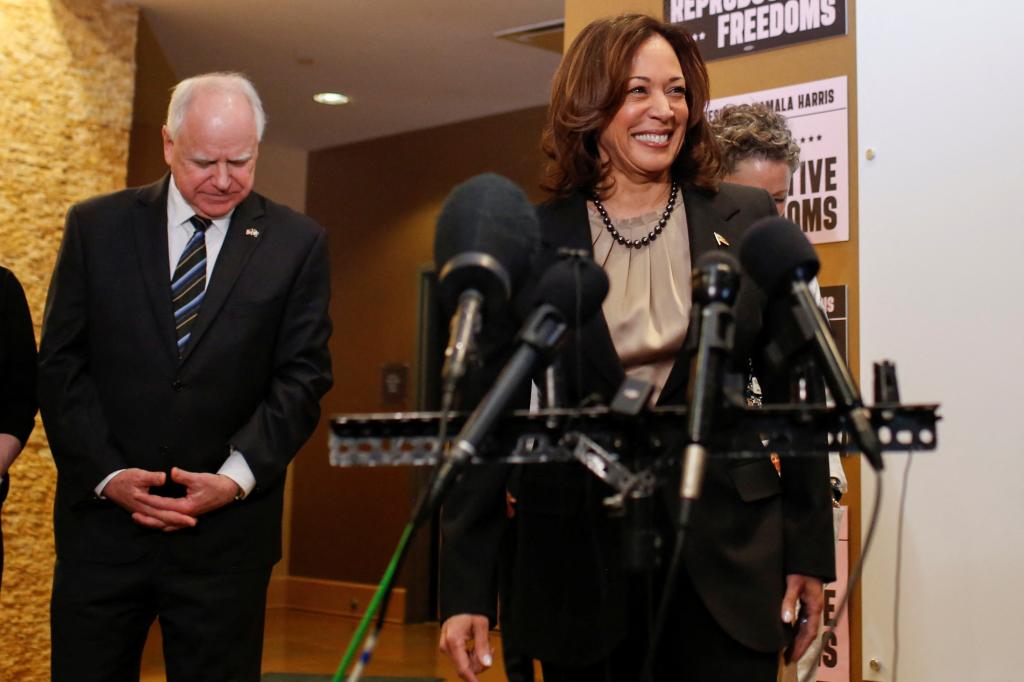 Kamala Harris at microphones with Tim Walz standing behind her