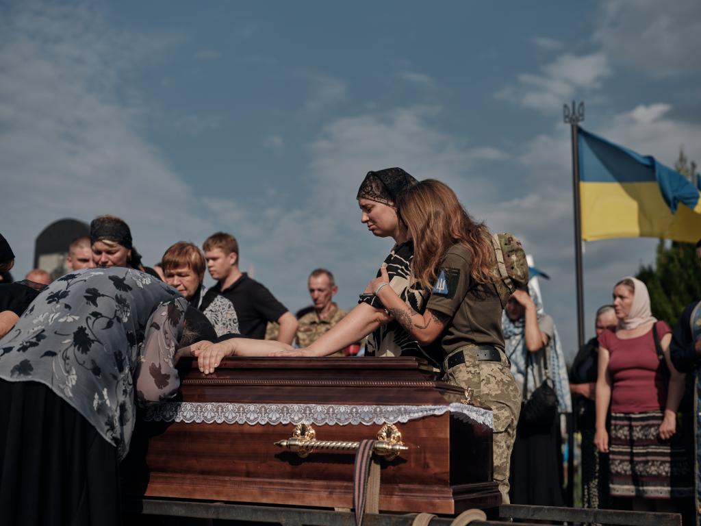 Mourners standing next to the coffin of Ukrainian F-16 pilot Oleksiy Mes during his burial ceremony in Shepetivka, Ukraine on August 29, 2024.