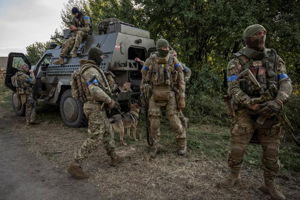 Ukrainian servicemen stand near a military vehicle, amid Russia's attack on Ukraine, on August 16.