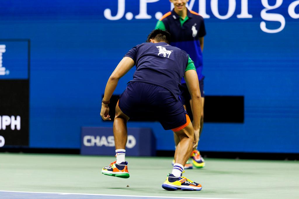 Two ball boys try to capture and kill a moth during Grigor Dimitrov of Bulgaria against Francis Tiafoe of USA.