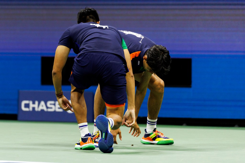 Two ball boys try to capture and kill a moth during Grigor Dimitrov of Bulgaria against Francis Tiafoe of USA in their Menâs Singles quarterfinal match at the 2024 US Open Championships played in the USTA Billie Jean King Tennis Center on September 3, 2024 in Flushing, New York.