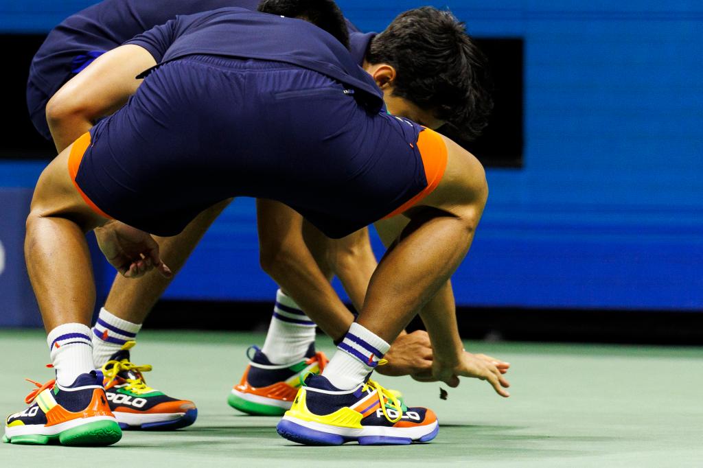 Two ball boys try to capture and kill a moth during Grigor Dimitrov of Bulgaria against Francis Tiafoe of USA in their Menâs Singles quarterfinal match at the 2024 US Open Championships played in the USTA Billie Jean King Tennis Center 