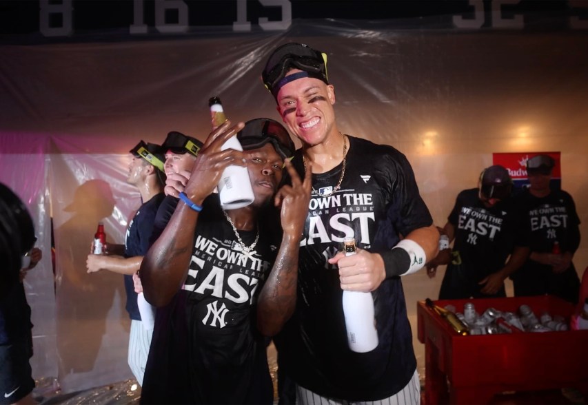 New York Yankees third baseman Jazz Chisholm Jr. #13 and New York Yankees center fielder Aaron Judge #99 celebrate in the clubhouse after defeating the Baltimore Orioles