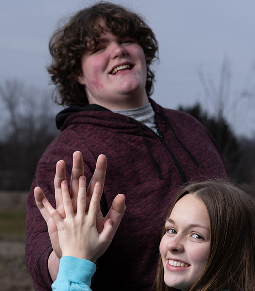 Eric Kilburn Jr. holding his hand up to another teen