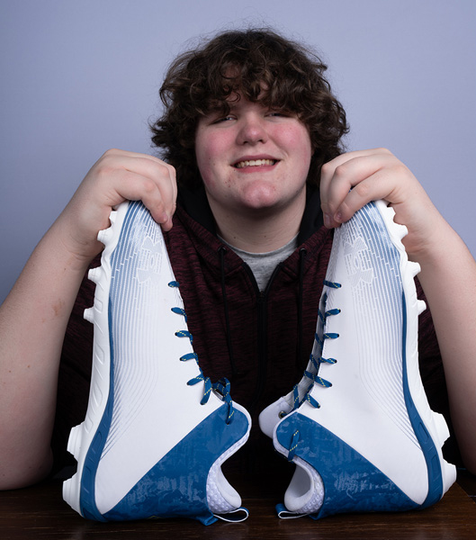 Eric Kilburn Jr. posing with his size 23 shoes 