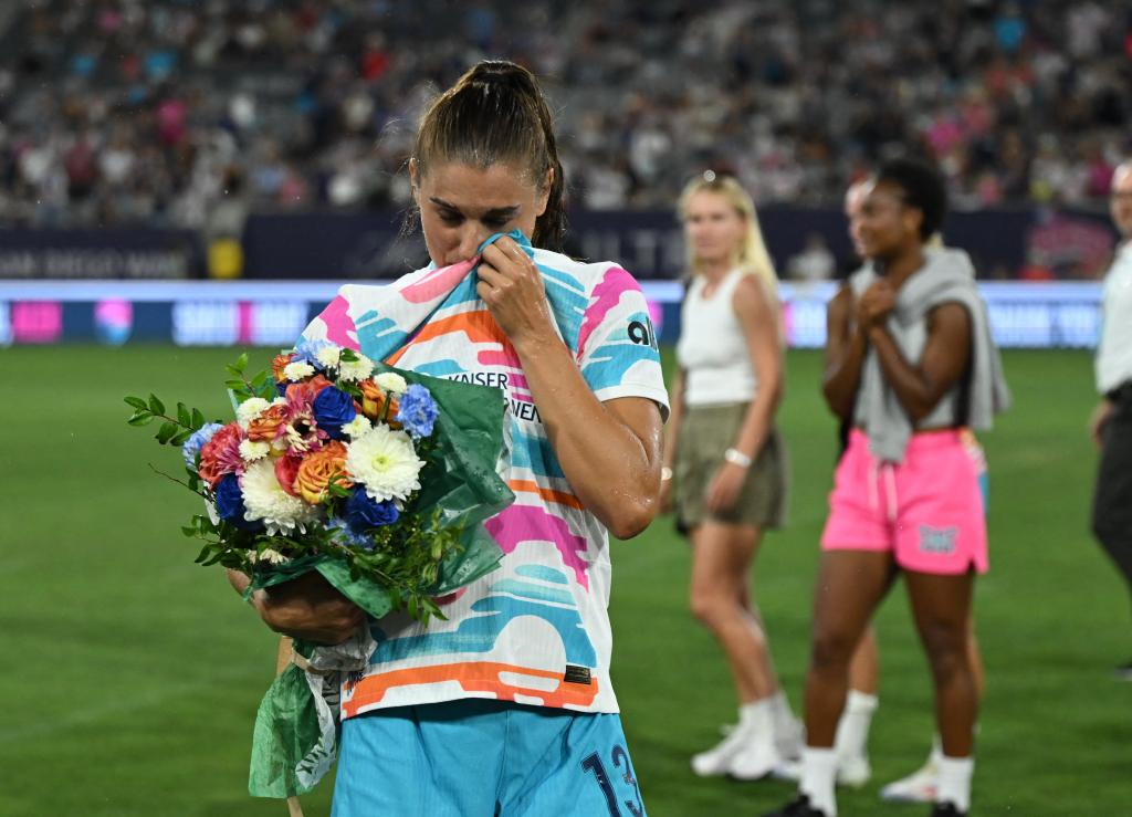 Alex Morgan (13) wipes her eyes after being sprayed with champagne following her final match before retirement 