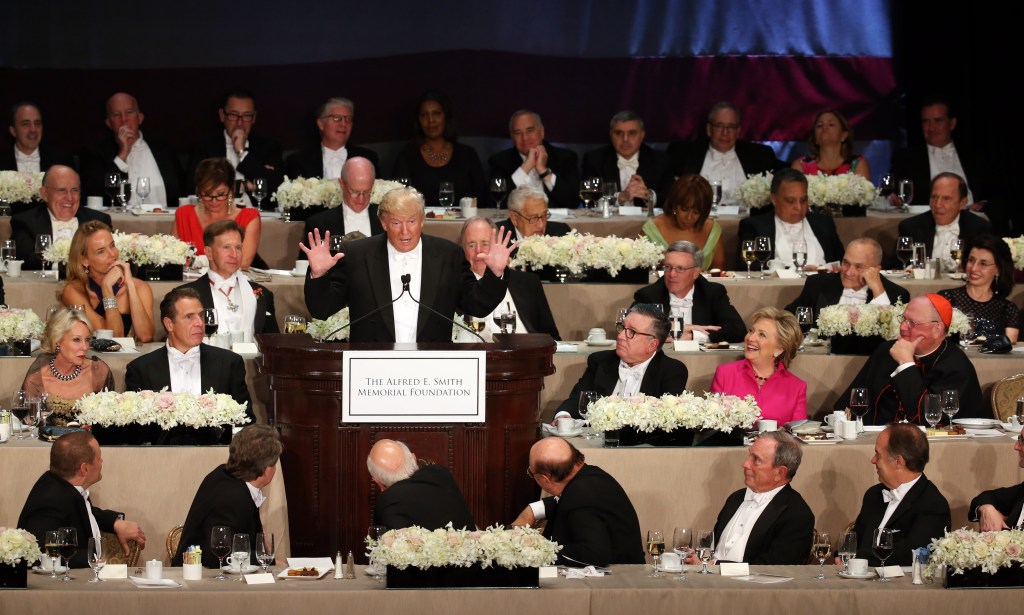 Donald Trump speaking at the podium during the 71st annual Alfred E. Smith Memorial Foundation Dinner surrounded by noted personalities