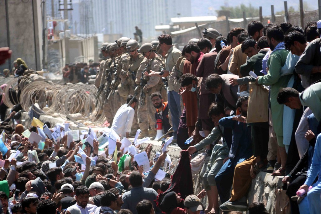 Afghans struggle to reach the foreign forces to show their credentials to flee the country outside the Hamid Karzai International Airport, in Kabul, Afghanistan, 26 August 2021