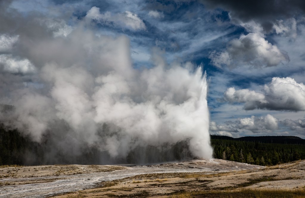 Old Faithful Geyser erupting at Yellowstone National Park's Upper Geyser Basin, showcasing its iconic hydrothermal features