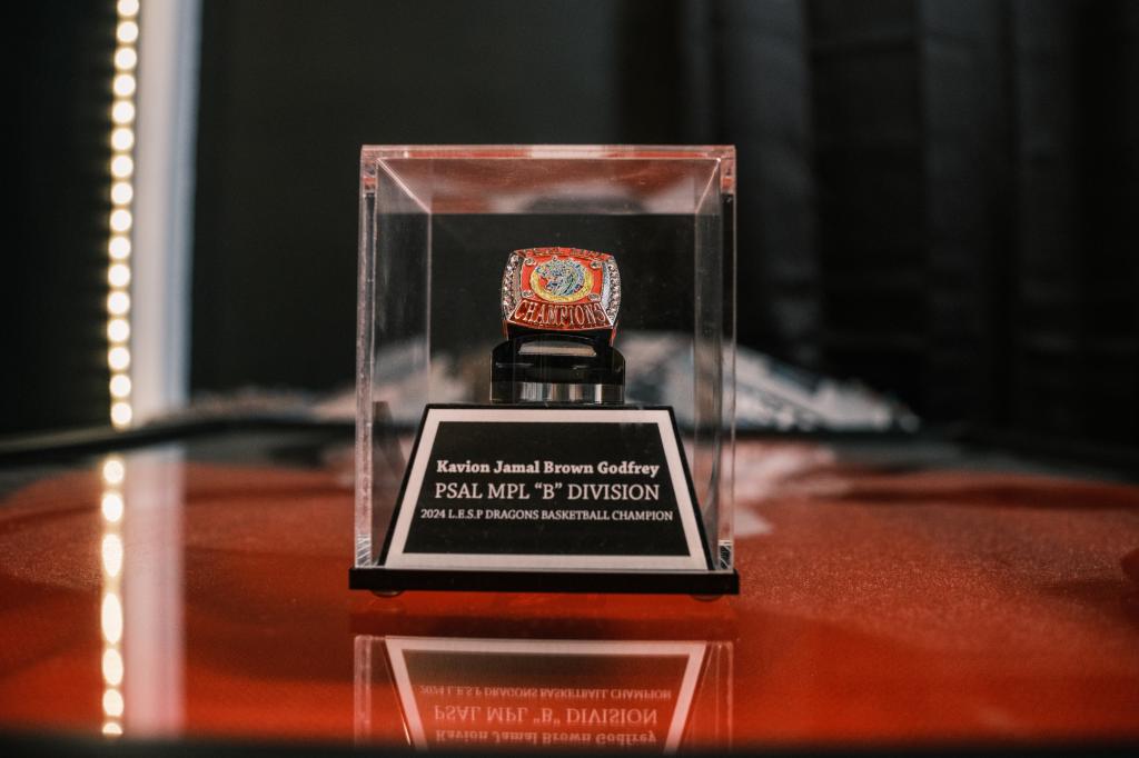 A sports championship ring of Kavion Brown Godfrey is in a case.