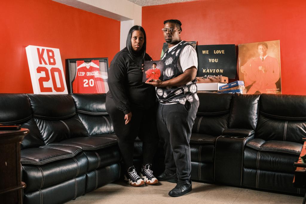 Laquana Badger Godfrey and Donnell Godfrey mourning, holding mementos of their drowned son, Kavion Brown Godfrey, in a room.