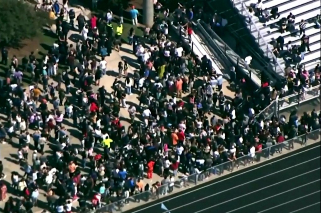 Students and staff gather next to the football field after law enforcement officers responded to a fatal shooting at Apalachee High School in a still image from aerial video in Winder, Georgia, U.S. September 4, 2024