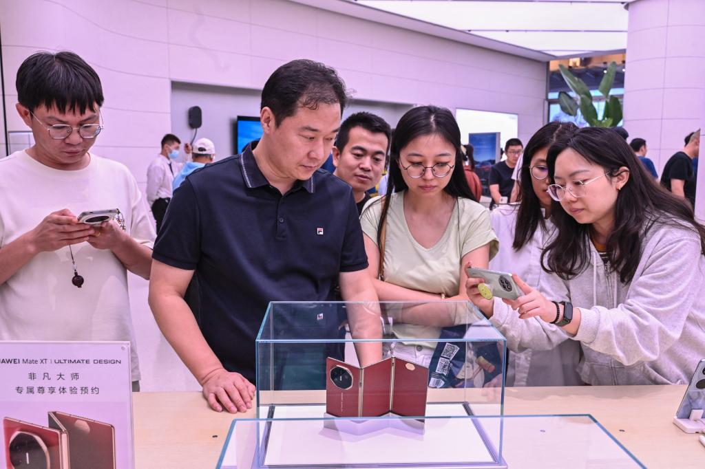 Visitors take pictures of Huawei Mate XT in Beijing store