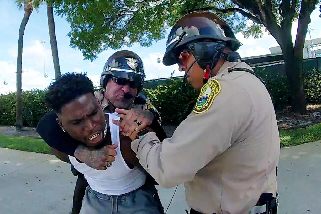 Miami Dolphins receiver Tyreek Hill is forced to the ground after being handcuffed and led to the sidewalk by Miami-Dade Police Department officers in Miami, Florida, September 8, 2024 in a still image from police body camera video.  