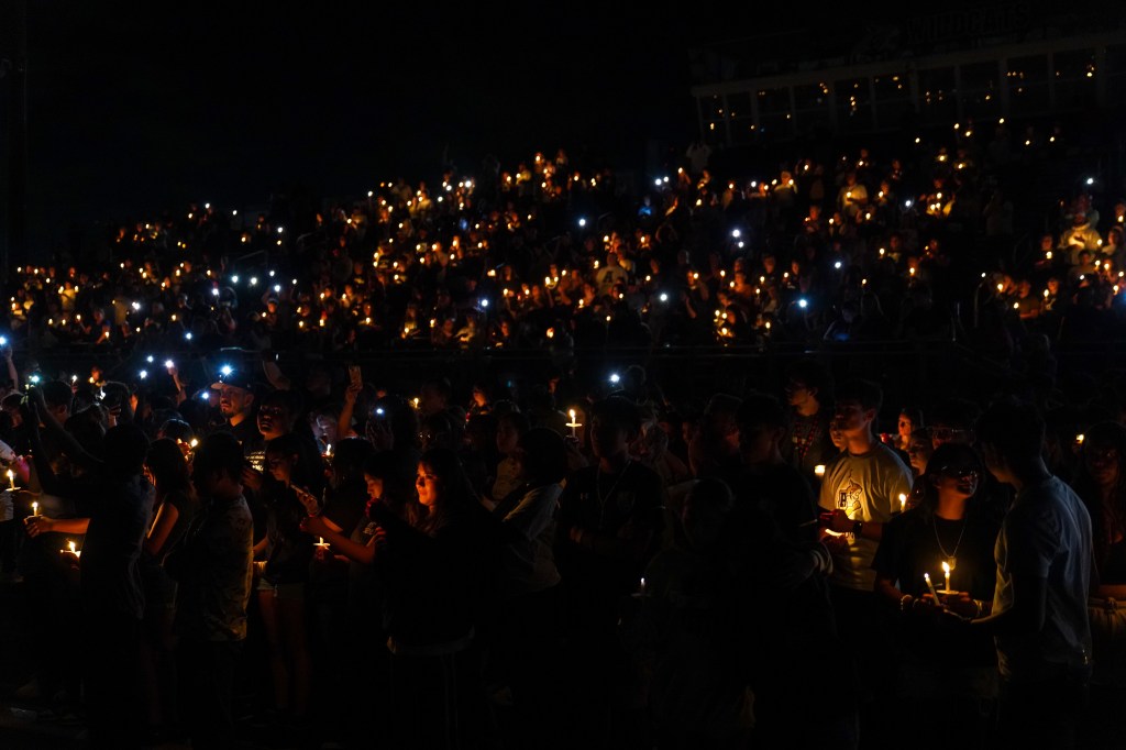 Students and faculty gather on the field at Apalachee High School to mourn and celebrate the lives of school shooting victims.