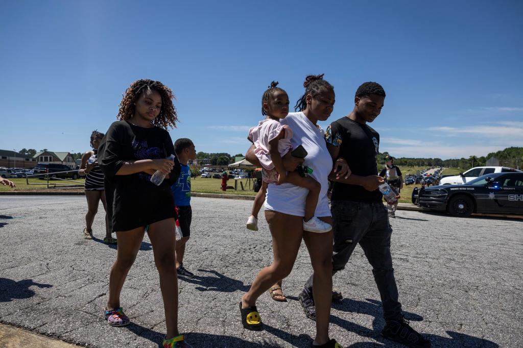 Parents and students leaving Apalachee High School after a shooting incident, with police at the scene