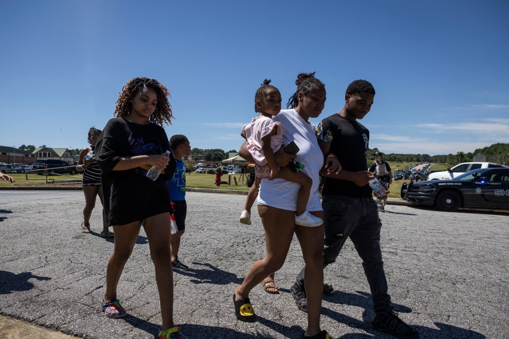 Parents and students leaving Apalachee High School after a shooting incident, with police at the scene