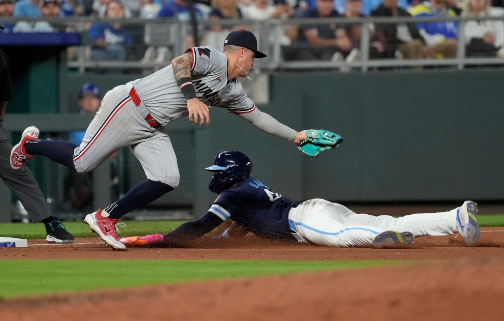 Dairon Blanco #44 of the Kansas City Royals slides into third past Jose Miranda #64 of the Minnesota Twins as he advances in the eighth inning at Kauffman Stadium on September 06, 2024 in Kansas City, Missouri.