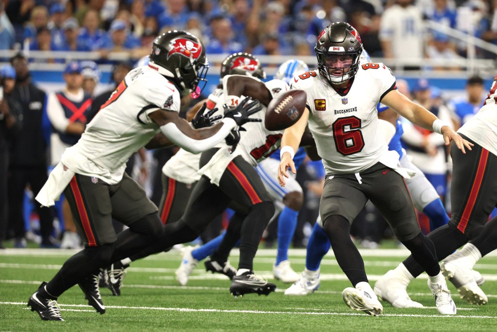 Quarterback Baker Mayfield #6 of the Tampa Bay Buccaneers passes the ball to Bucky Irving #7 against the Detroit Lions during the fourth quarter at Ford Field on September 15, 2024 in Detroit, Michigan. 