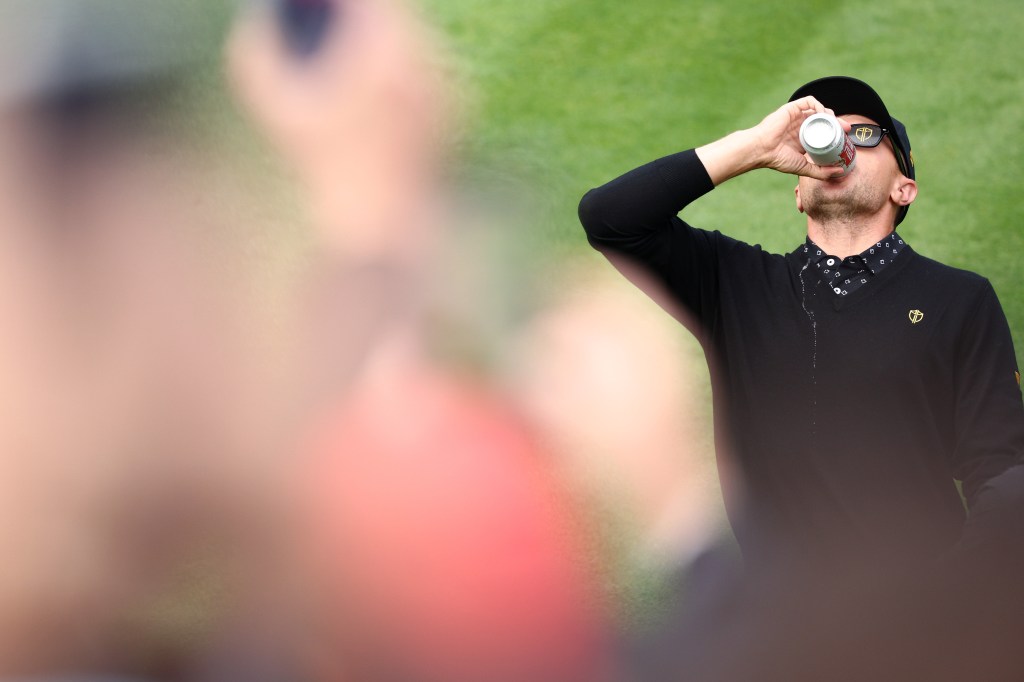 Mackenzie Hughes of Canada and the International Team chugs a beer on the first tee during Thursday's Four-ball matches on day one of the 2024 Presidents Cup at The Royal Montreal Golf Club on September 26, 2024 in Montreal, Quebec, Canada. 