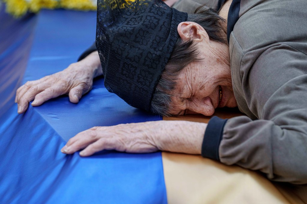 A mother cries near the coffin of her son killed in a Russian rocket attack at a Ukrainian military academy, during his funeral ceremony in Poltava, Ukraine, Saturday Sept. 7, 2024.