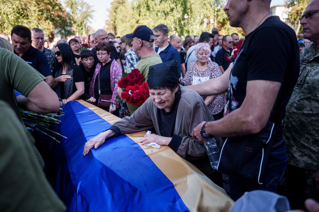 A mother cries near the coffin of her son killed in a Russian rocket attack at a Ukrainian military academy, during his funeral ceremony in Poltava, Ukraine, Saturday Sept. 7, 2024. 