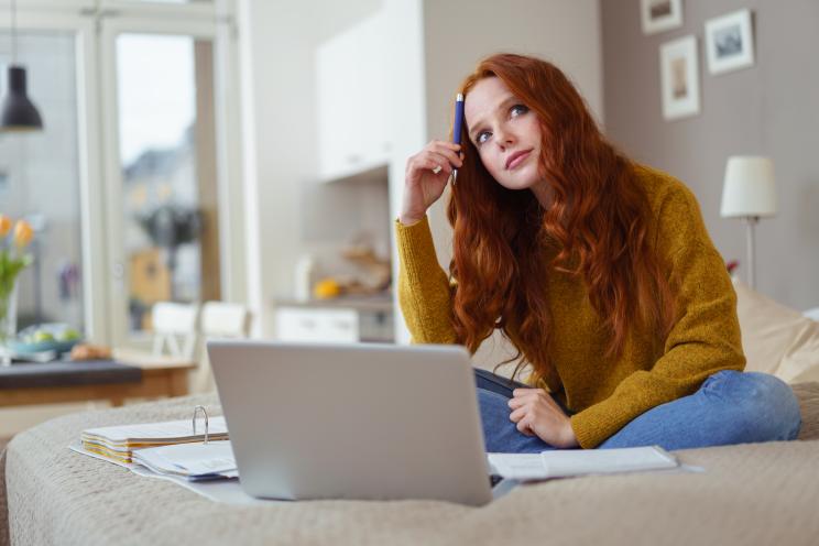 Student pondering looking up with laptop in front of her