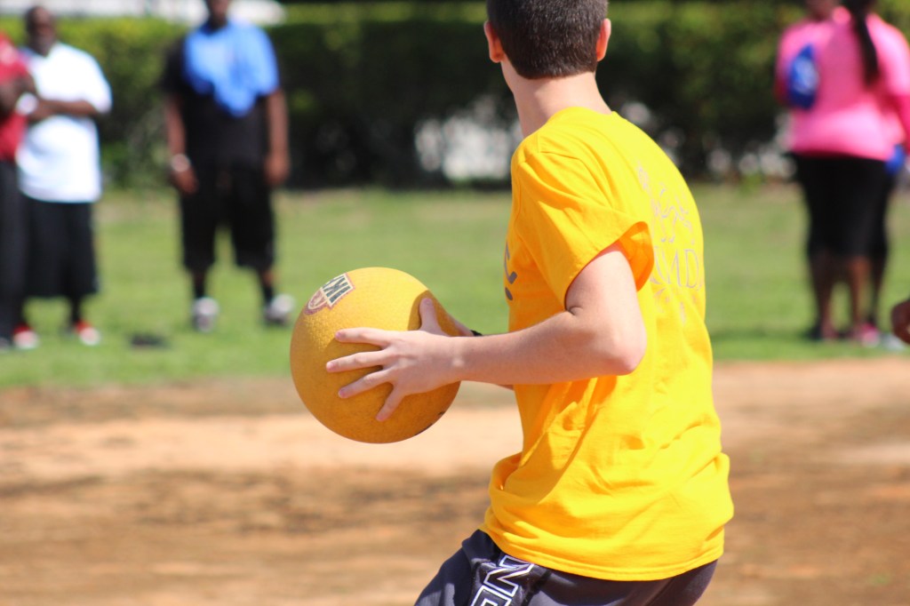 A boy named Leo Mars holding a yellow ball, ready to play a kickball game