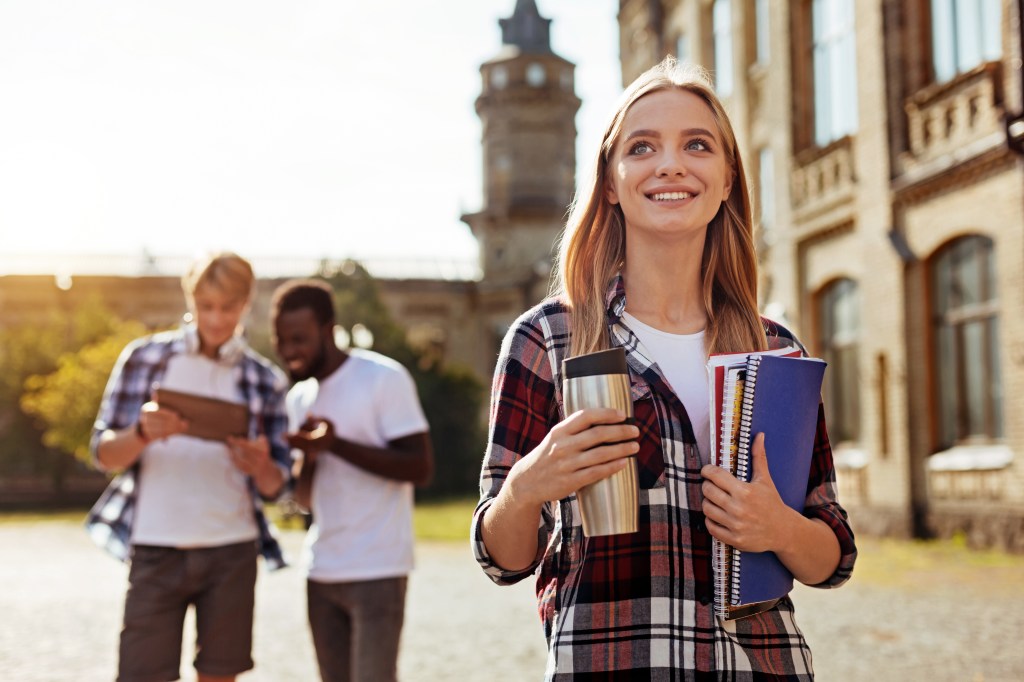 Jolly freshman. Dedicated diligent vibrant girl heading to the class while attending university and being excited