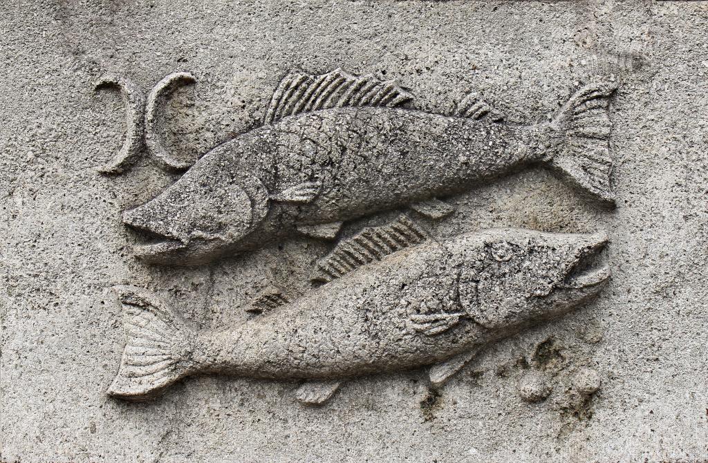 Stone relief carving of the Zodiac sign, Pisces, represented by fish