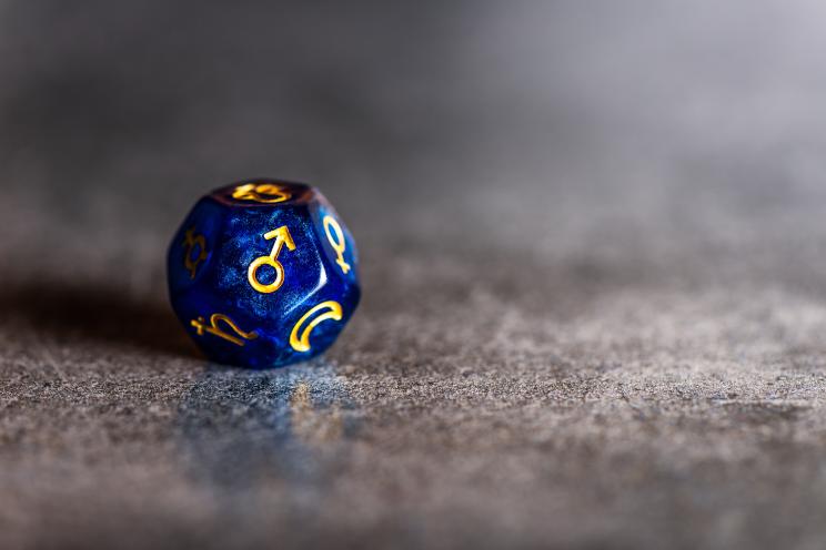 Blue Astrology Dice with symbol of the planet Mars on dark grey background