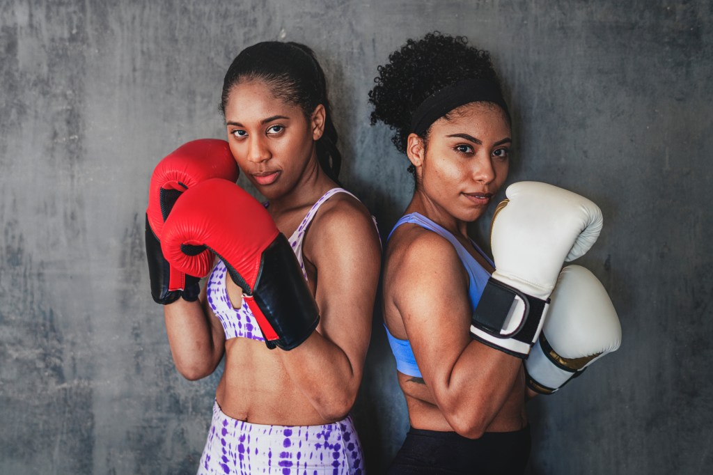 Two muscular sportive women ready to box, demonstrating strength and fitness.