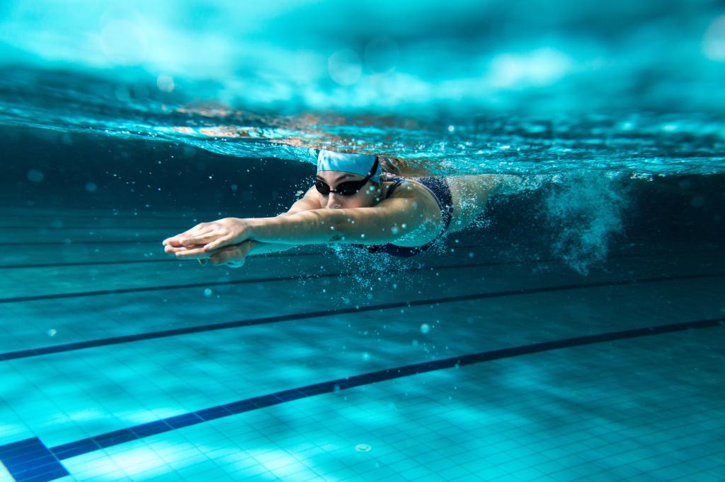 A woman swimming underwater in a pool