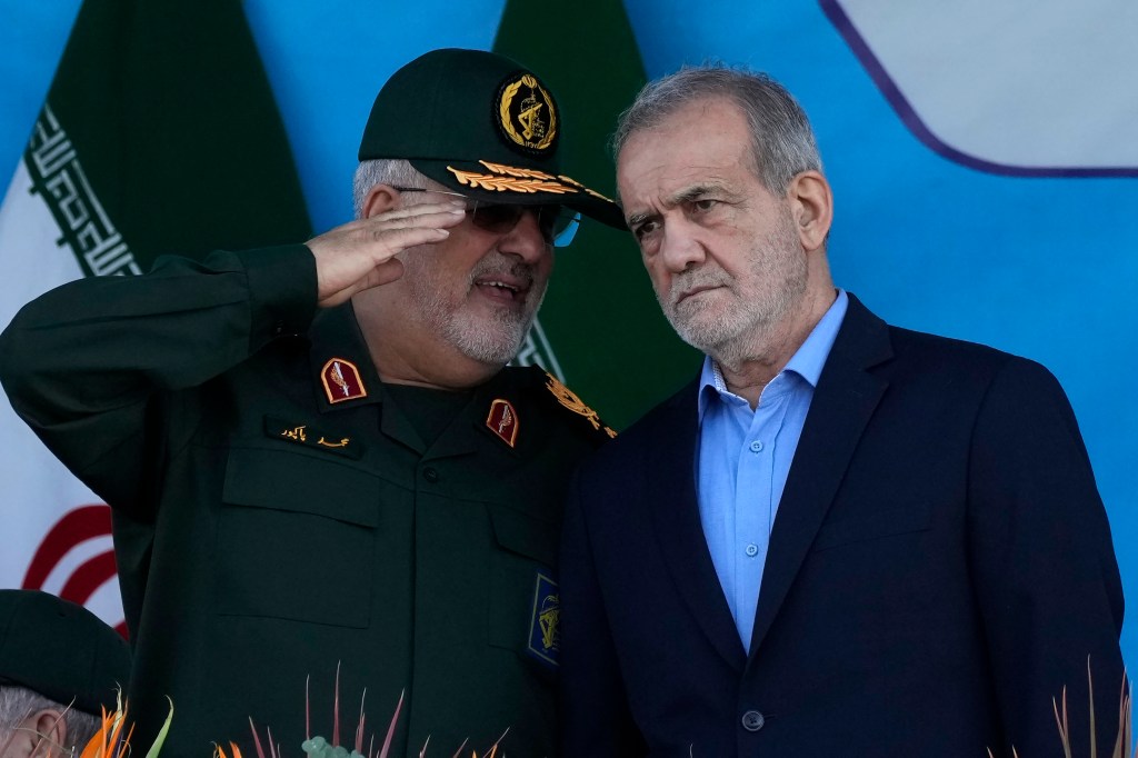 Iranian President Masoud Pezeshkian, right, listens to commander of the Revolutionary Guard's ground force Gen. Mohammad Pakpour as he reviews an annual armed forces parade marking the anniversary of the beginning of war against Iran by former Iraqi Dictator Saddam Hussein 44 years ago, in front of the shrine of the late revolutionary founder Ayatollah Khomeini, just outside Tehran, Iran, Saturday, Sept. 21, 2024