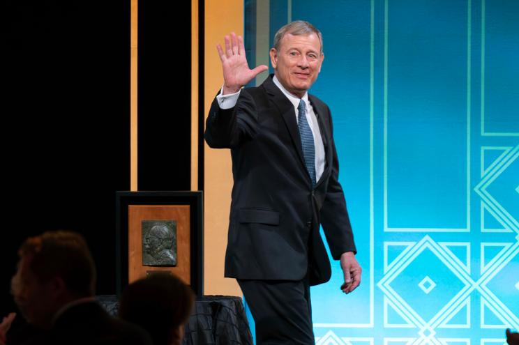 Supreme Court Chief Justice John Roberts waves to the crowd after he received the Henry J. Friendly Medal during the American Law Institute's annual dinner in Washington, Tuesday, May 23, 2023.