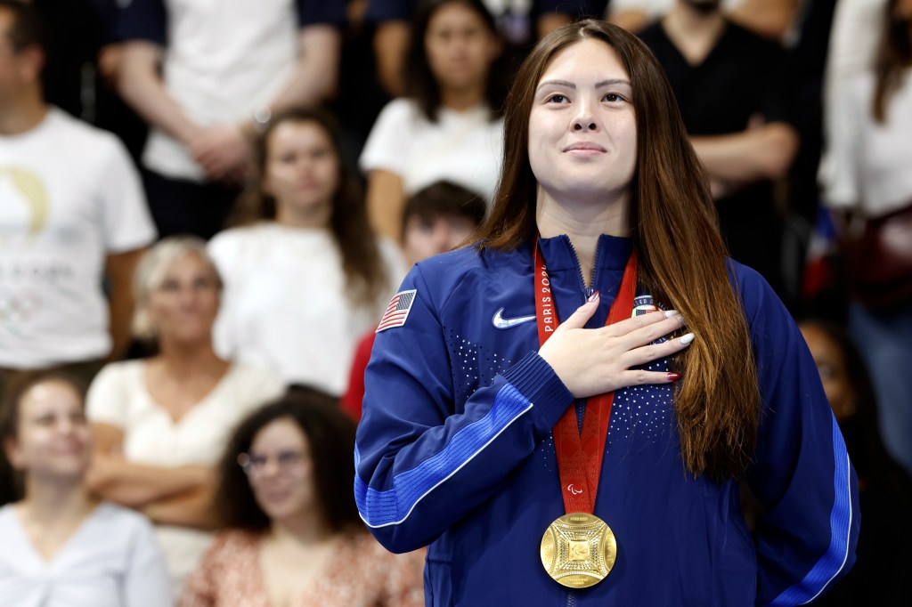 Gia Pergolini from the U.S. stands on the podium with her gold medal after winning the women's 100 meter backstroke S13 during the Paralympic Games in Paris, Friday, Aug. 30, 2024. 