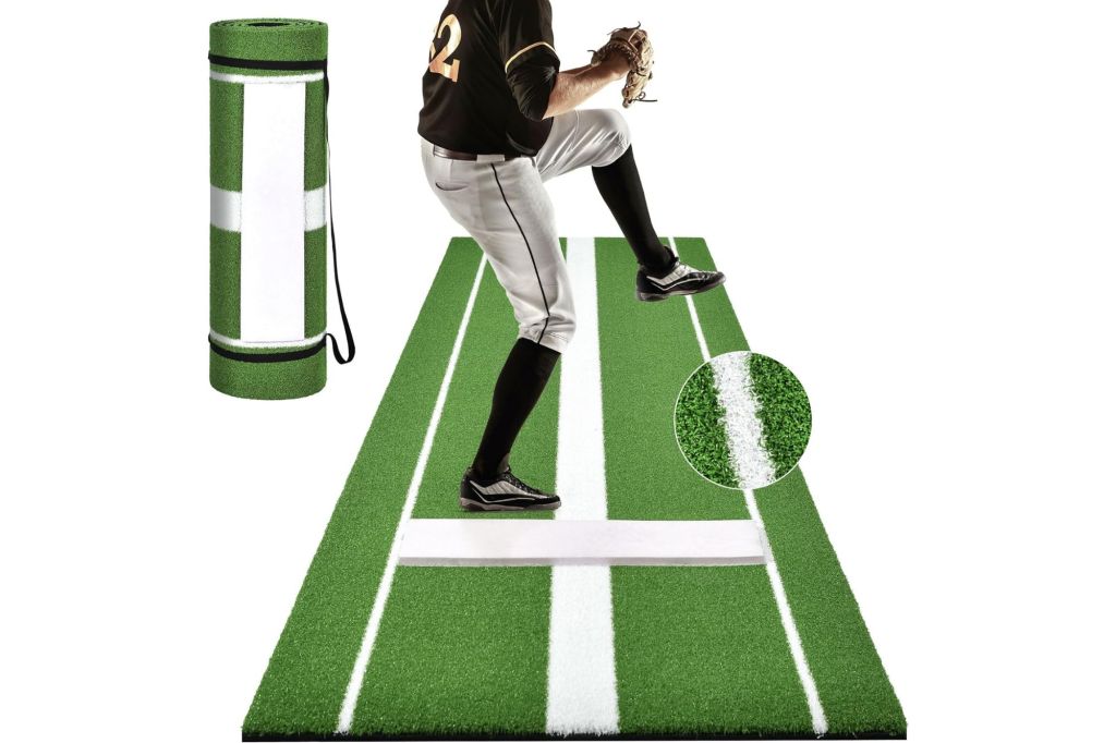 A man standing on a portable softball pitch turf.